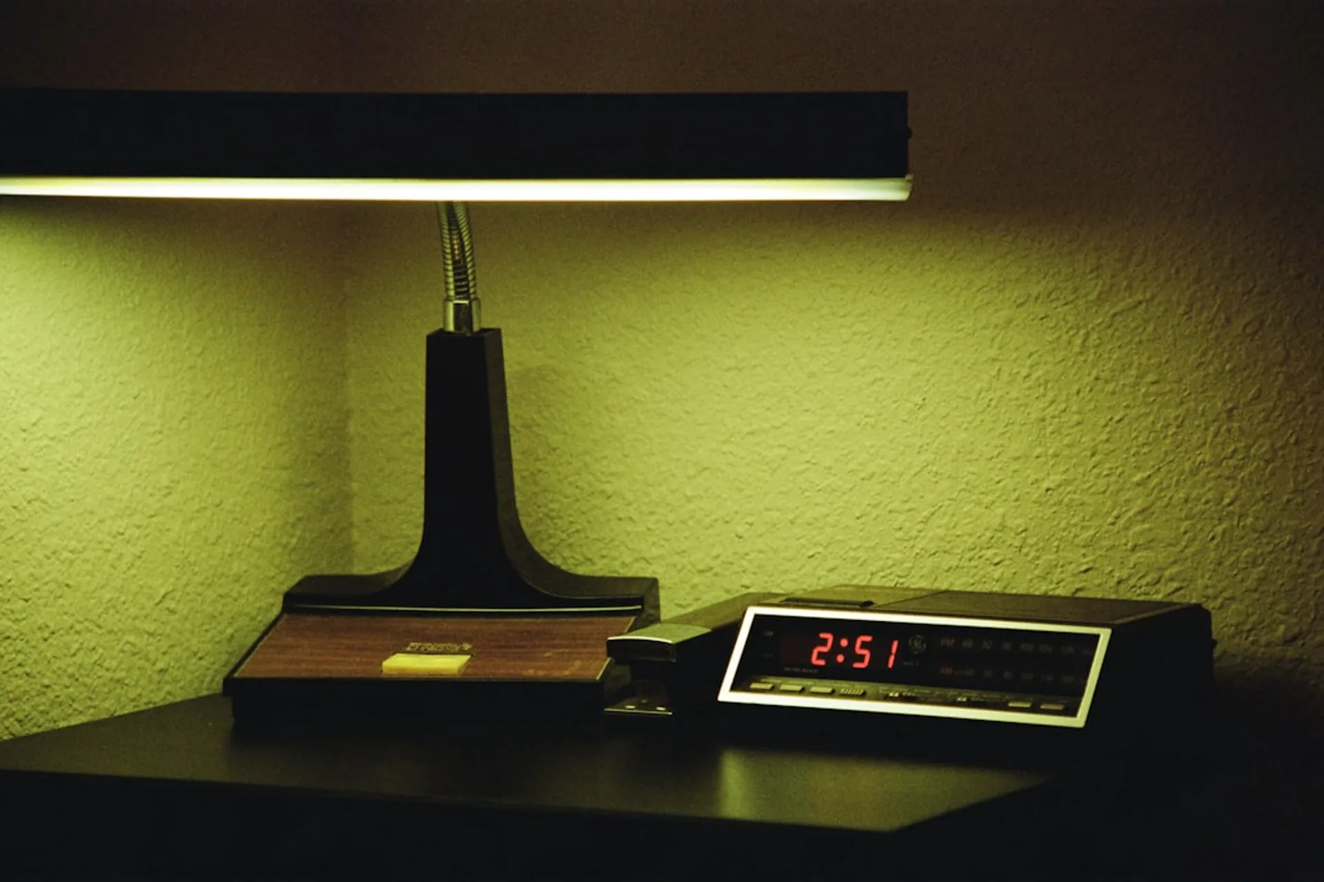 Warm bedside lamp illuminating a smartphone displaying a sleep sound timer interface