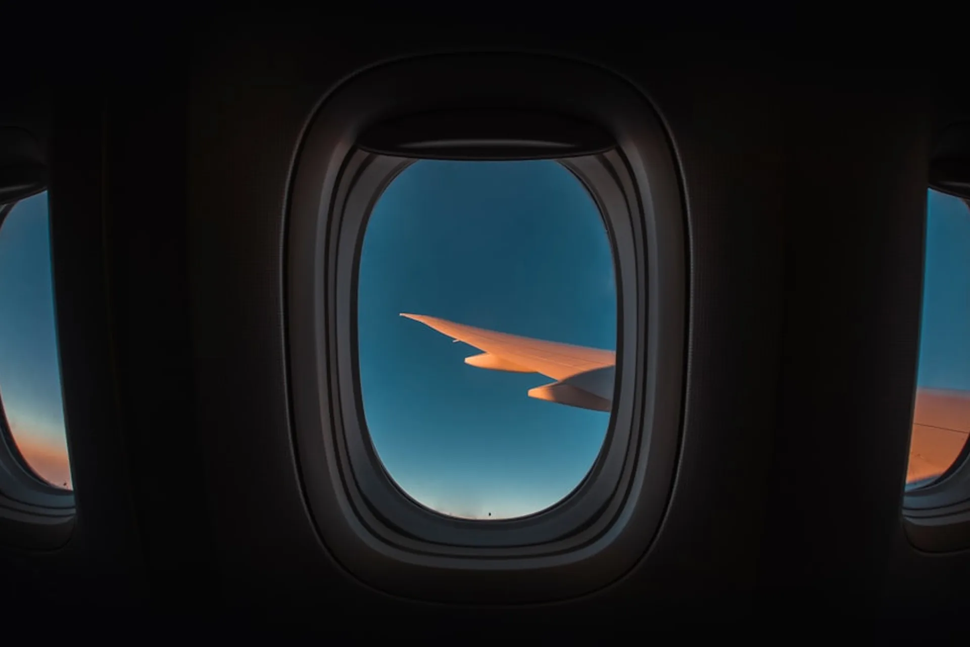 Nighttime view from an airplane window showing stars and city lights